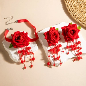 Detailed view of red velvet rose choker necklace with beaded tassels on stone base