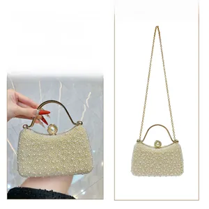 Elegant ivory pearl evening bag featuring gold handle and detachable chain strap detail