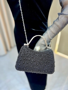 Detail of beaded evening bag with silver metal handle and large pearl clasp decoration