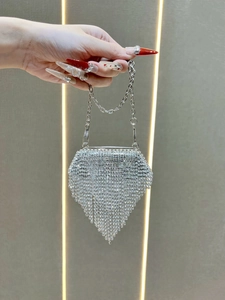 Close-up of luxury silver rhinestone mini bag with diamond fringe and chain strap
