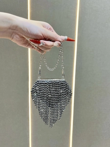 Detail of silver rhinestone evening bag with V-shaped tassel and chain strap for parties