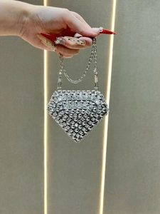 Detail of silver diamond-shaped evening bag with sparkling rhinestones and chain strap