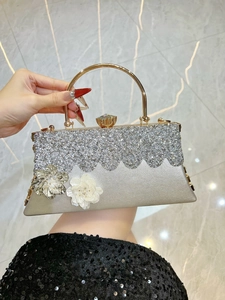 Macro view of silver evening clutch featuring rhinestones and metal flower details