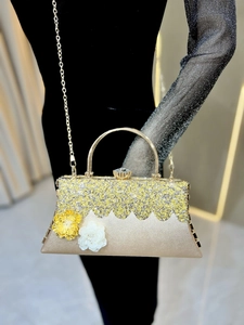 Detail of evening clutch featuring champagne gold sequins and 3D floral accents