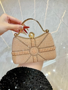 Detailed view of handmade pearl evening clutch with gold metal handle and radiant pattern