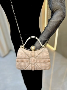 Close-up of pearl evening bag with champagne tone, gold frame and chain strap