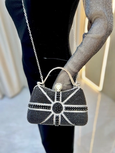 Detail of elegant black beaded evening bag with sunburst rhinestone pattern and pearl clasp