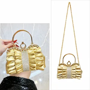 Gold pleated evening bag showing handheld and crossbody styles with rhinestone detail