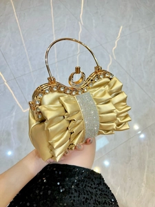 Elegant gold pleated evening bag with sparkling rhinestone bow detail and metal handle
