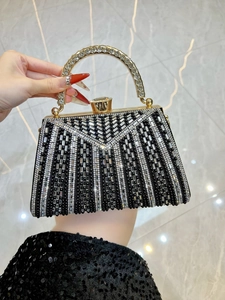 Detail of beaded evening bag with rhinestone-encrusted gold handle for formal gala events