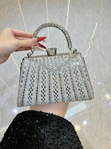 Detail of luxury evening bag featuring pearls, rhinestones and gemstone clasp