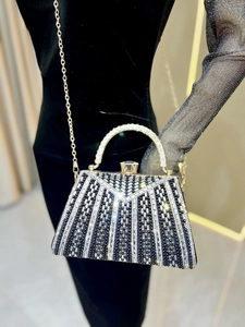 Detailed view of luxury evening bag with black and silver rhinestones and metal handle