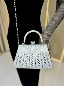 Macro detail of luxury dinner bag featuring V-shaped pearl and rhinestone embroidery