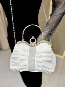 Detail of white pleated evening bag featuring sparkling rhinestones and gold handle