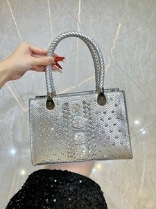 Detail of silver snake-embossed handbag featuring crystal flower embellishments