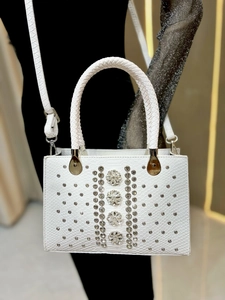 Detailed view of white snake-embossed leather handbag with luxury crystal floral embellishments