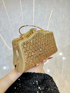 Dettaglio della pochette dorata con motivi traforati glitterati e chiusura in cristallo