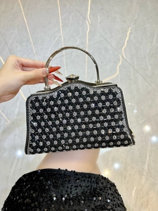 Dettaglio borsa da sera nera con motivi geometrici in strass e manico in metallo argento