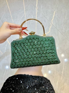 Dettaglio borsa da sera verde con strass, manico dorato e chiusura con gioiello