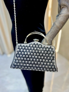 Dettaglio della borsa da sera con strass, motivo geometrico esagonale e manico in metallo