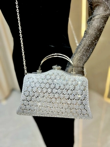 Dettaglio elegante pochette in strass argento con manico e catena per eventi gala