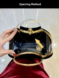 Détail du sac de soirée en velours noir avec poignée dorée et bandoulière chaîne