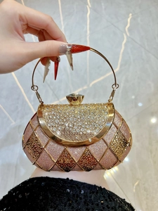 Macro shot of rhinestone bow evening clutch with metal handle and champagne glitter