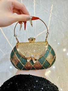 Detailed view of luxury green sequin evening bag with crystal bow and gold ring handle
