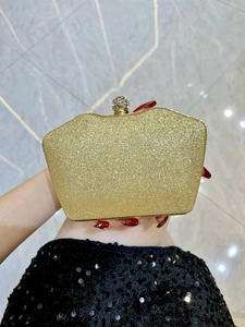 Close-up of glitter evening clutch with sparkling rhinestone ball clasp and gold hardware
