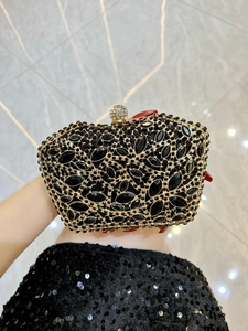 Macro detail of luxury black gemstone clutch with gold hollow metal and crystal spherical lock