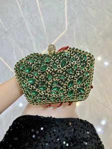 Macro view of crystal encrusted evening bag with green rhinestones and gold metal frame