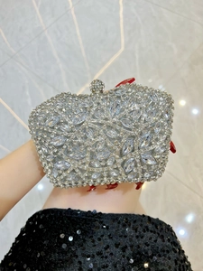 Macro detail of luxury silver evening bag with floral crystal patterns and diamond clasp