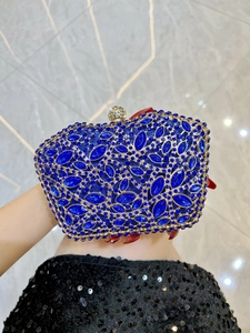 Detail of sapphire blue rhinestone evening clutch with gold metal frame and crystal clasp