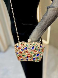 Detailed shot of a luxury evening clutch bag with multicolored rhinestones and chain strap