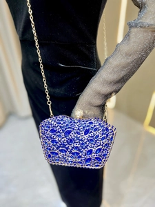 Detail of dark blue crystal evening bag with gold metal frame and rhinestone clasp