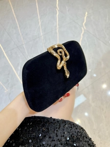 Elegant black velvet evening clutch featuring a gold snake buckle with rhinestone details