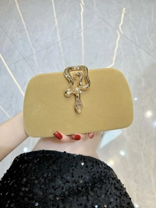 Detailed macro view of velvet evening clutch with gold snake clasp and rhinestones