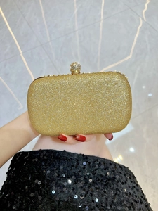Detail of glitter clutch bag with a rhinestone-encrusted spherical metal clasp closure