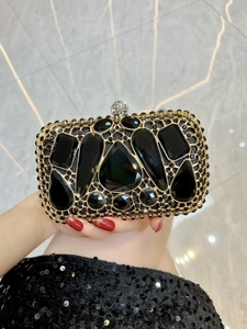 Detail of luxury evening clutch with black rhinestones and gold hollow metal frame