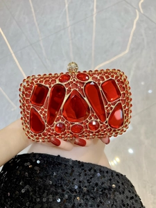Close-up of luxury red rhinestone evening clutch with gold mesh and gemstone lock detail