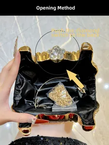 Détail du sac de soirée doré en strass montrant la doublure noire et la chaînette