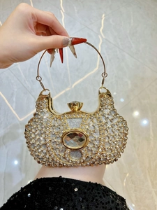 Détail du sac de soirée avec grand cristal et poignée anneau en métal doré brillant