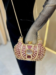 Détail d'une pochette de soirée de luxe avec paillettes rouges, strass et chaîne dorée