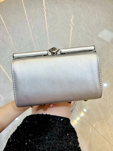 Detail shot of a silver evening clutch bag with pearlescent finish and metal clasp