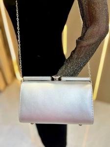 Detail of silver metallic evening bag featuring a fine glitter finish and chain strap