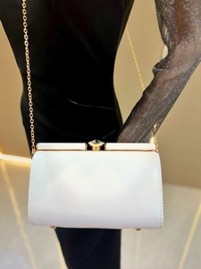 Detail of ivory faux leather evening bag with gold chain and gem-shaped clasp
