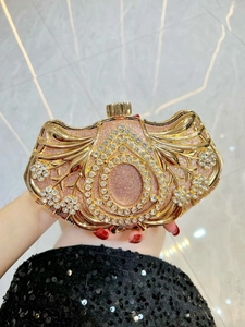 Macro view of champagne gold evening clutch with hollow floral frame and rhinestones