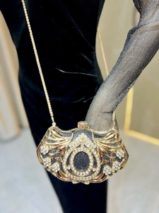Detail of luxury evening clutch with sparkling rhinestones and golden metal chain
