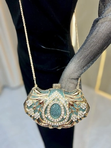 Detail of luxury emerald dinner clutch featuring gold filigree and sparkling rhinestones