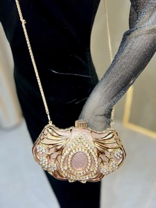 Detail of evening clutch featuring intricate gold cutout patterns and pavé crystals